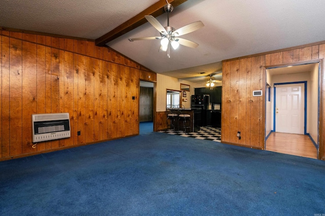 unfurnished living room featuring carpet, lofted ceiling with beams, heating unit, and wooden walls