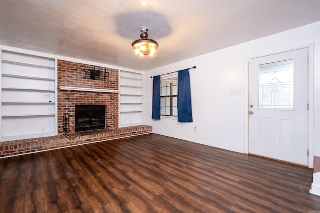 unfurnished living room featuring a brick fireplace, dark hardwood / wood-style flooring, and built in features