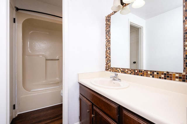 bathroom featuring decorative backsplash, toilet, vanity, and hardwood / wood-style flooring