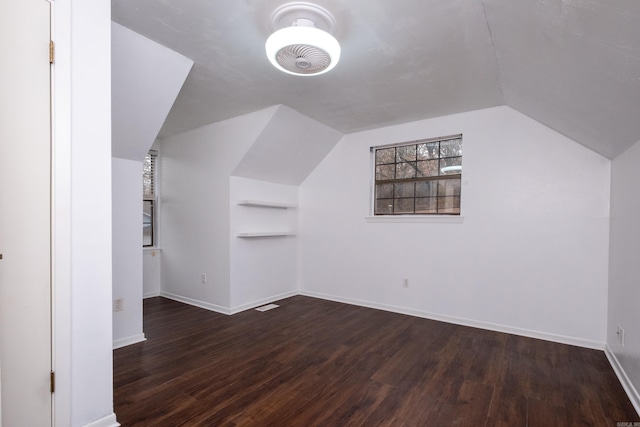 additional living space with vaulted ceiling and dark hardwood / wood-style floors