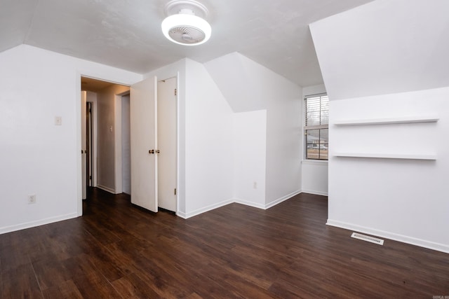 additional living space featuring dark wood-type flooring and vaulted ceiling