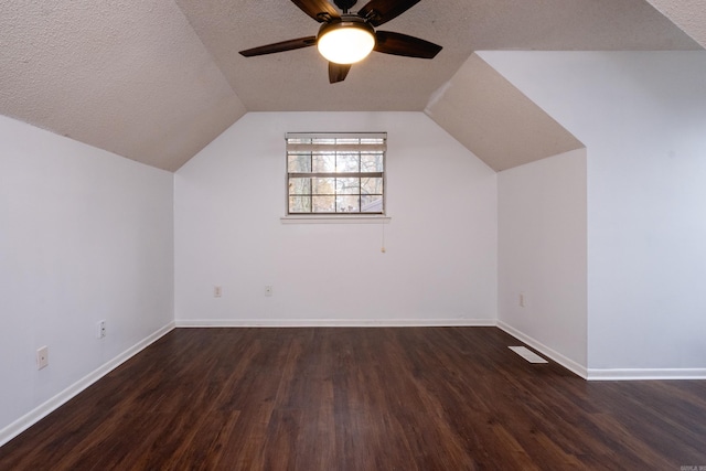 additional living space with dark hardwood / wood-style floors, ceiling fan, lofted ceiling, and a textured ceiling