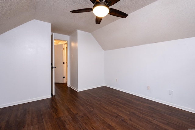 bonus room with dark hardwood / wood-style flooring, a textured ceiling, and vaulted ceiling