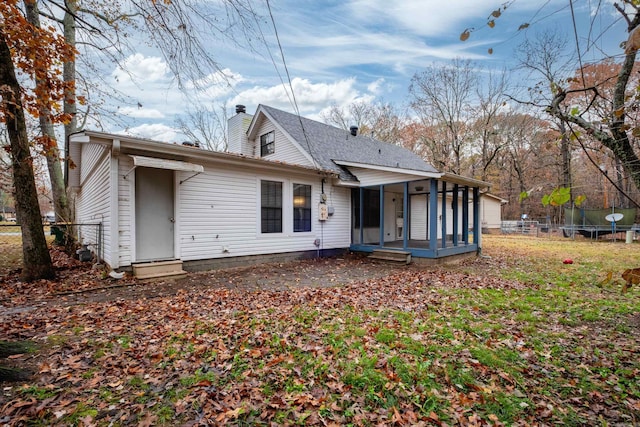 rear view of house with a sunroom and a trampoline