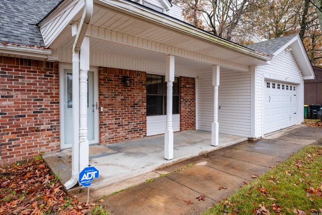 doorway to property with a garage and covered porch