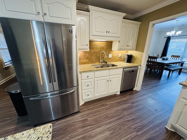 kitchen featuring sink, stainless steel appliances, a notable chandelier, crown molding, and white cabinets