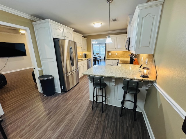 kitchen featuring white cabinets, a kitchen breakfast bar, stainless steel appliances, and dark hardwood / wood-style floors