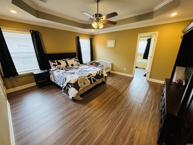 bedroom featuring dark hardwood / wood-style floors, ornamental molding, and multiple windows