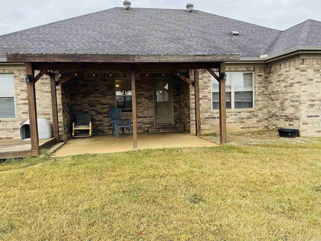 rear view of house featuring a lawn and a patio