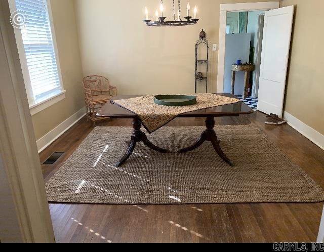 dining area featuring dark hardwood / wood-style flooring and an inviting chandelier