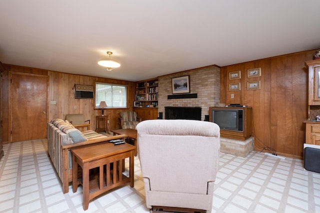 living room featuring built in shelves, a brick fireplace, and wood walls