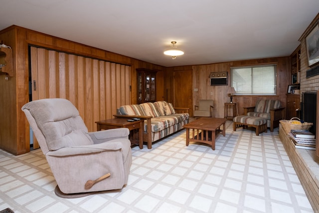 living room featuring wooden walls and a brick fireplace