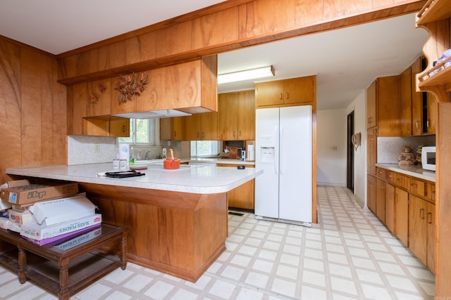 kitchen featuring white appliances, kitchen peninsula, and tasteful backsplash