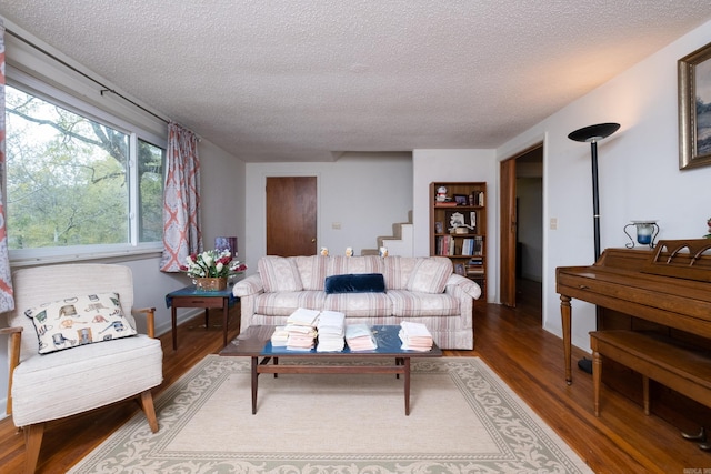 living room featuring wood-type flooring and a textured ceiling