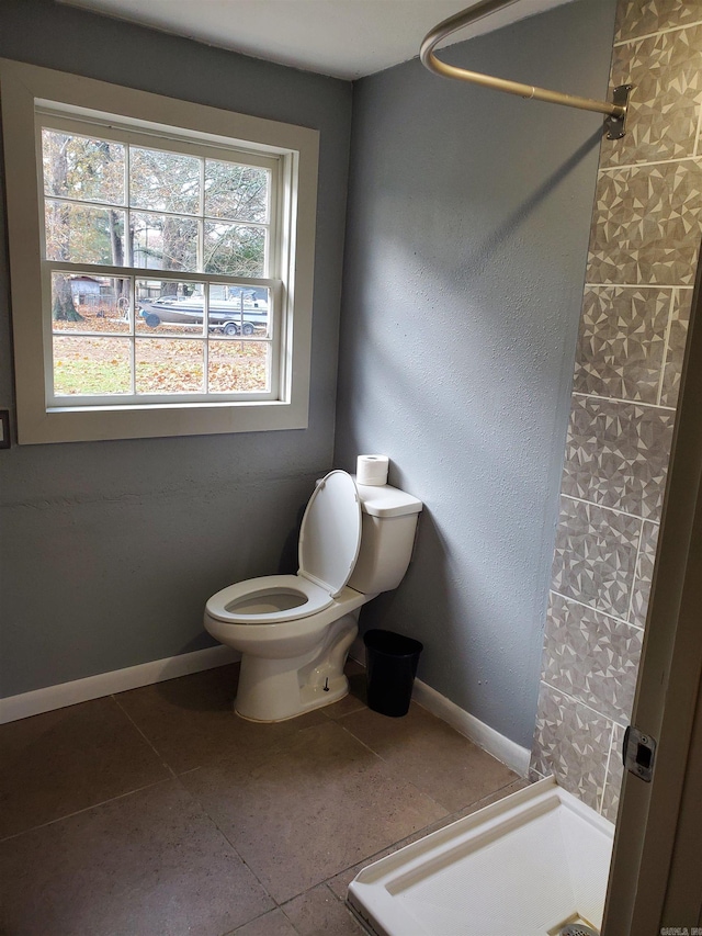 bathroom featuring tile patterned floors, toilet, and a shower