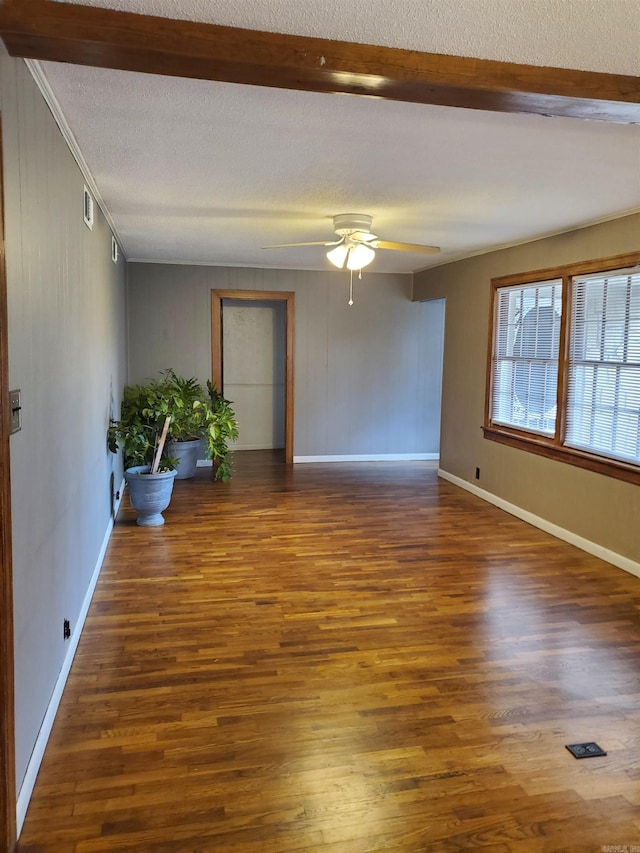 spare room with beamed ceiling, crown molding, ceiling fan, and dark wood-type flooring