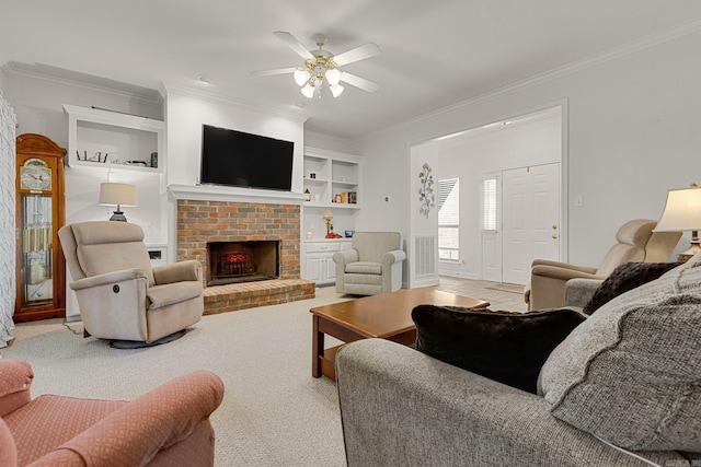 carpeted living room featuring ceiling fan, built in features, crown molding, and a brick fireplace