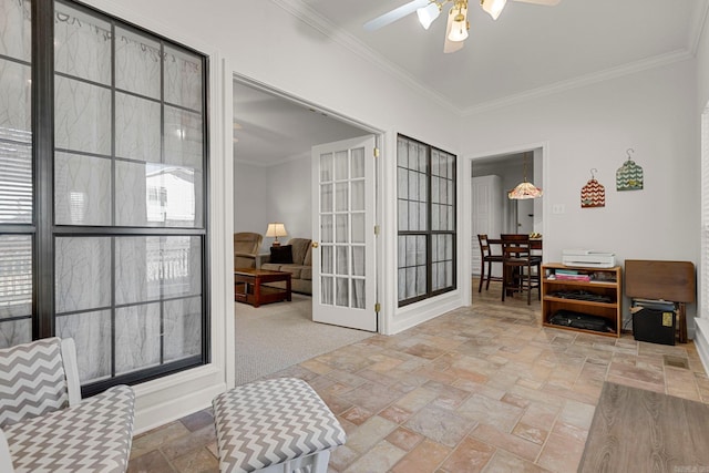 sitting room with carpet, ceiling fan, and ornamental molding