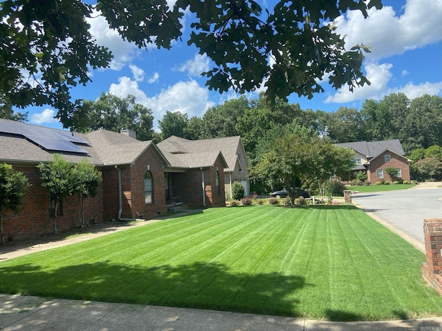 view of front of house with solar panels and a front yard