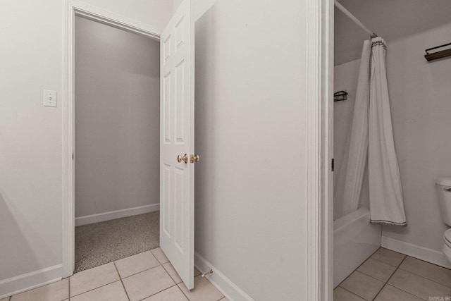 bathroom with tile patterned floors, shower / bath combo, and toilet