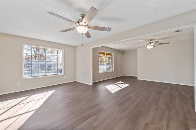 unfurnished living room with ceiling fan, dark hardwood / wood-style flooring, and a textured ceiling