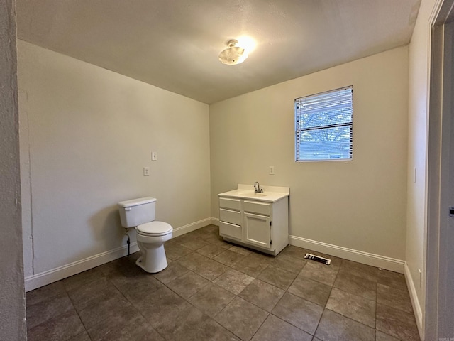 bathroom with tile patterned flooring, vanity, and toilet