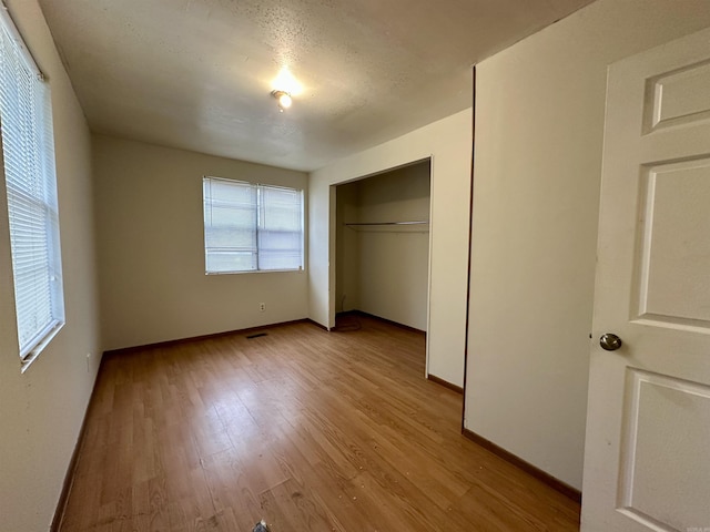 unfurnished bedroom featuring light wood-type flooring and a closet