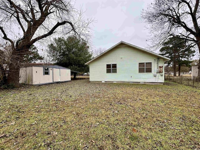 rear view of house with a yard and a shed