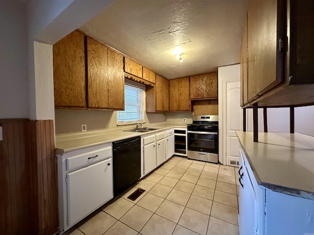 kitchen with sink, a textured ceiling, black dishwasher, stainless steel range, and light tile patterned flooring