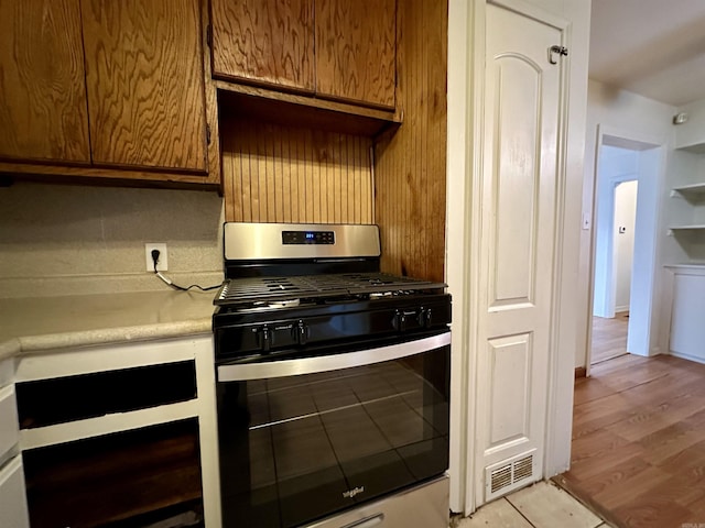 kitchen with stainless steel range with gas cooktop and light hardwood / wood-style flooring