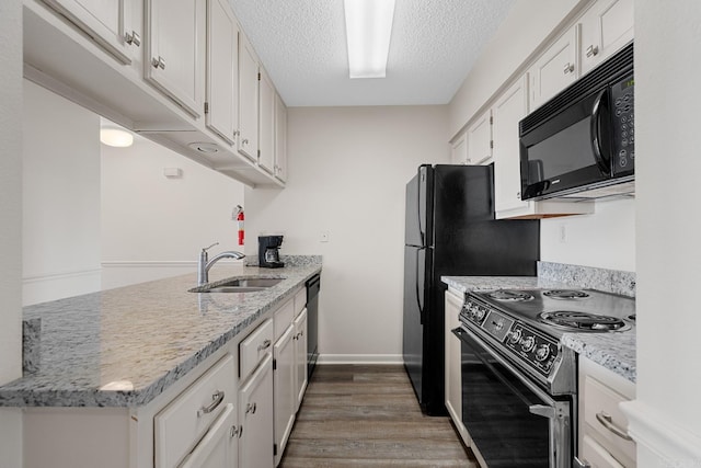 kitchen featuring light stone countertops, sink, dark hardwood / wood-style flooring, white cabinets, and black appliances