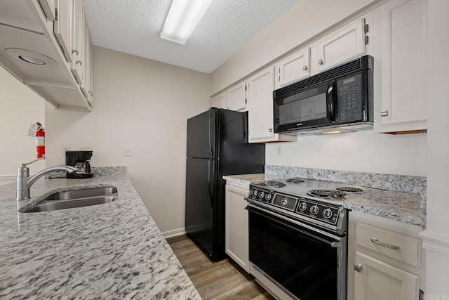 kitchen with white cabinetry, sink, a textured ceiling, black appliances, and light wood-type flooring