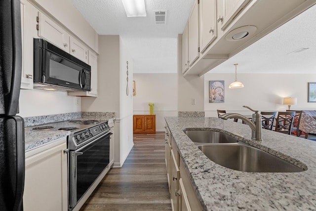 kitchen with electric range oven, sink, decorative light fixtures, white cabinets, and dark hardwood / wood-style floors