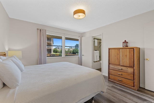 bedroom with hardwood / wood-style floors and a textured ceiling