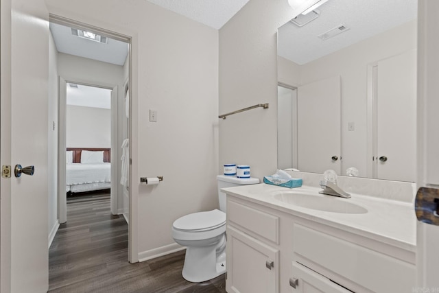 bathroom featuring hardwood / wood-style floors, vanity, a textured ceiling, and toilet