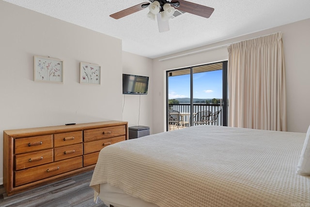 bedroom featuring ceiling fan, dark hardwood / wood-style floors, a textured ceiling, and access to outside