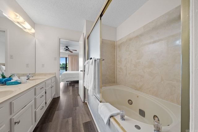 bathroom featuring ceiling fan, vanity, wood-type flooring, and a textured ceiling