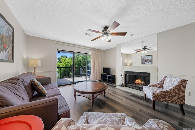 living room with hardwood / wood-style floors, a textured ceiling, and ceiling fan