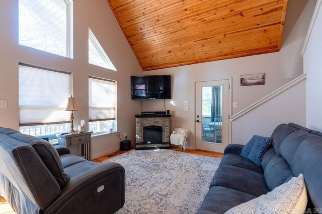 living room featuring a stone fireplace, plenty of natural light, and hardwood / wood-style floors