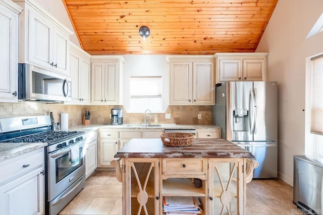 kitchen with wood counters, a center island, stainless steel appliances, and lofted ceiling