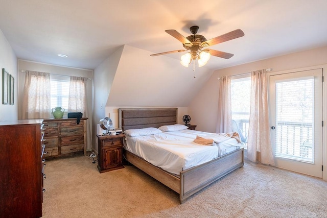 carpeted bedroom featuring access to exterior, multiple windows, vaulted ceiling, and ceiling fan