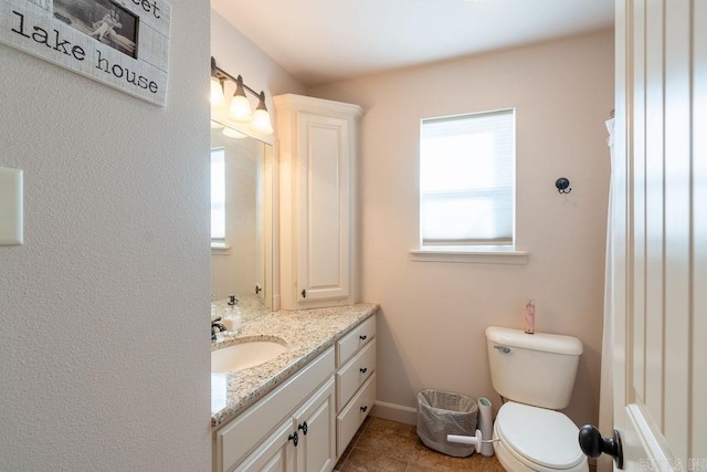 bathroom with toilet, vanity, and tile patterned floors