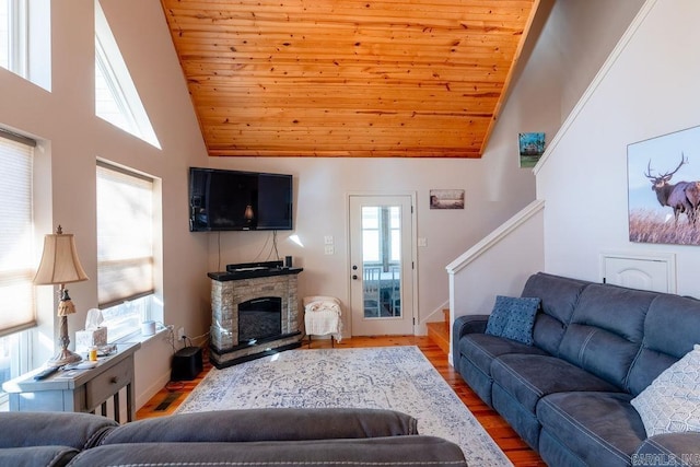 living room with a fireplace, plenty of natural light, and light hardwood / wood-style flooring