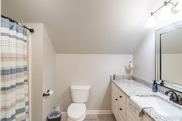 bathroom featuring walk in shower, vanity, vaulted ceiling, and toilet