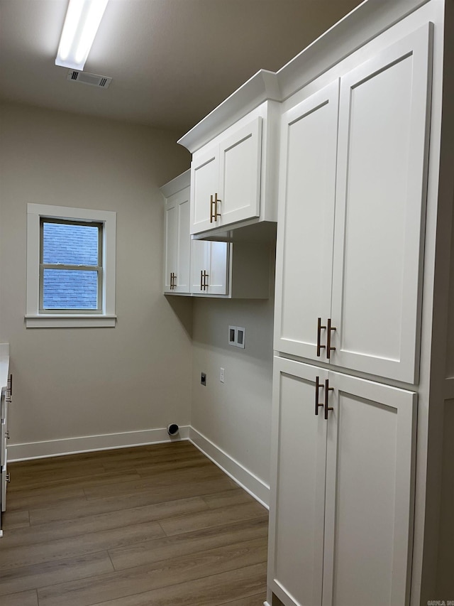 laundry area featuring cabinets, hookup for an electric dryer, washer hookup, and light hardwood / wood-style floors