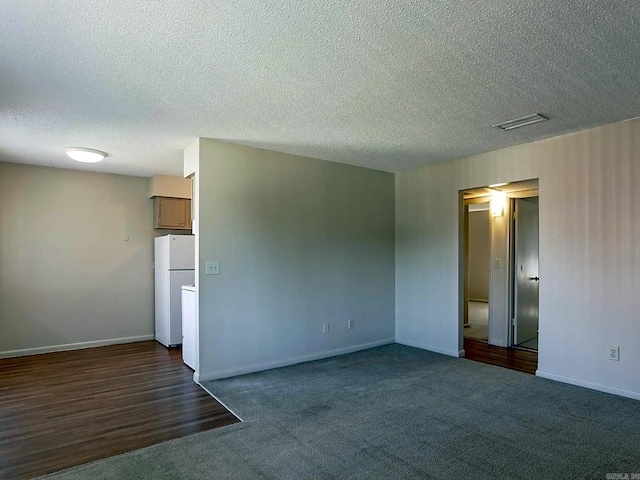 empty room featuring dark wood-type flooring and a textured ceiling