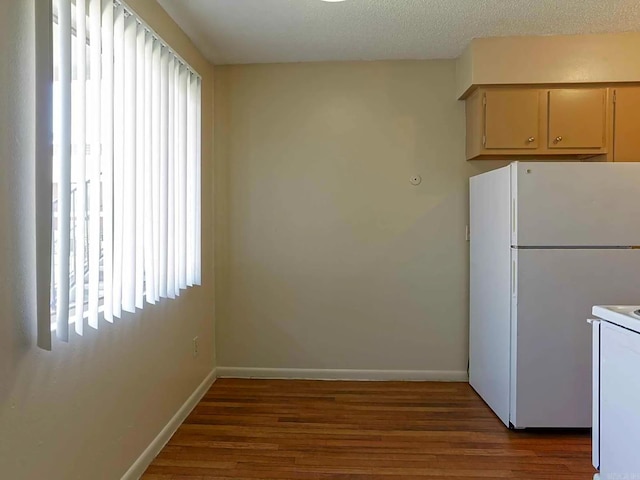 kitchen featuring hardwood / wood-style flooring, white appliances, and a textured ceiling