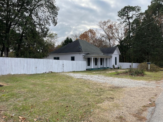 view of side of home featuring a lawn and covered porch