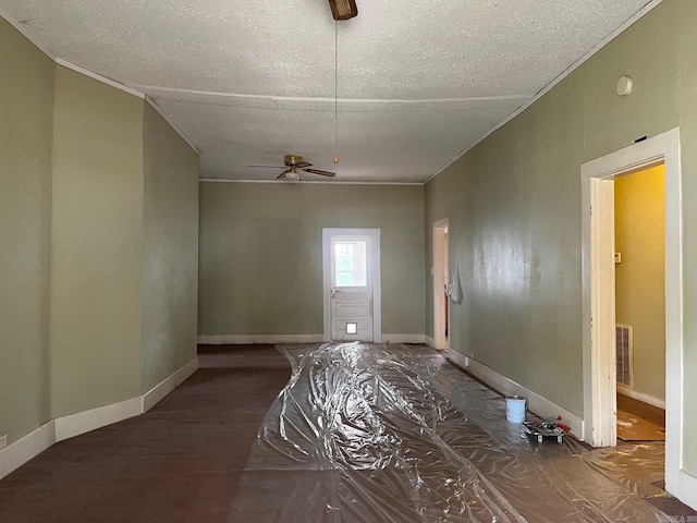 spare room featuring a textured ceiling, ceiling fan, and dark wood-type flooring