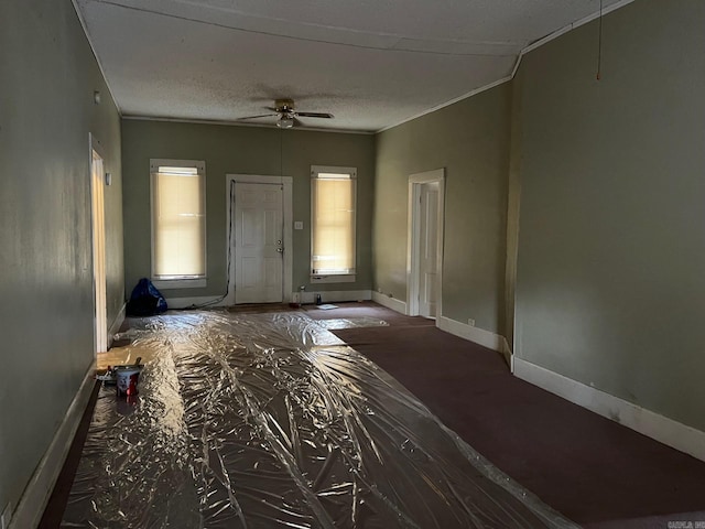 foyer featuring ceiling fan, crown molding, and a textured ceiling